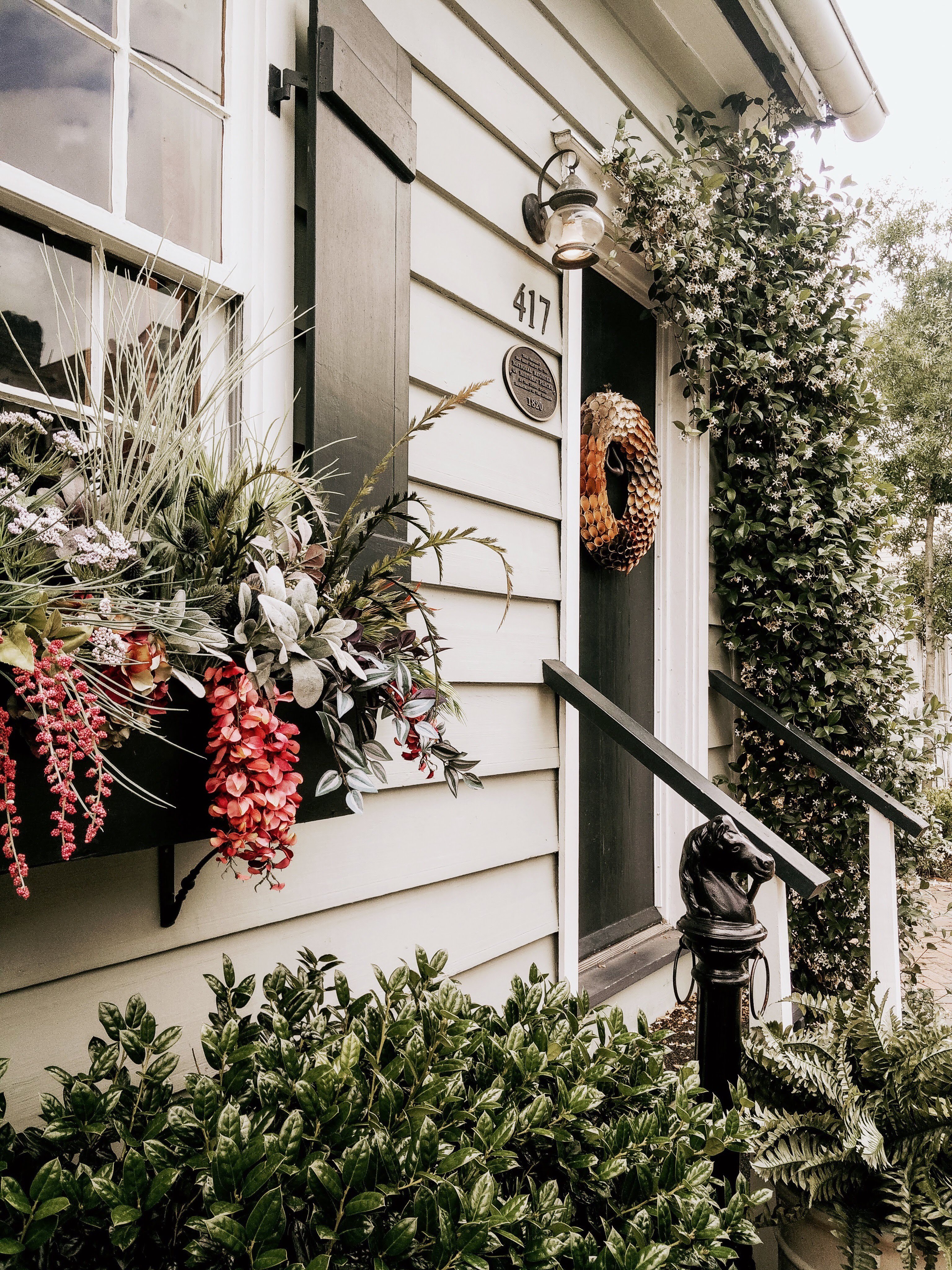 Home entrance with a flower box and climbing white-flowered vine