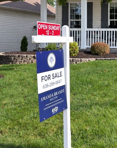 A 'For Sale' yard sign in front of a home