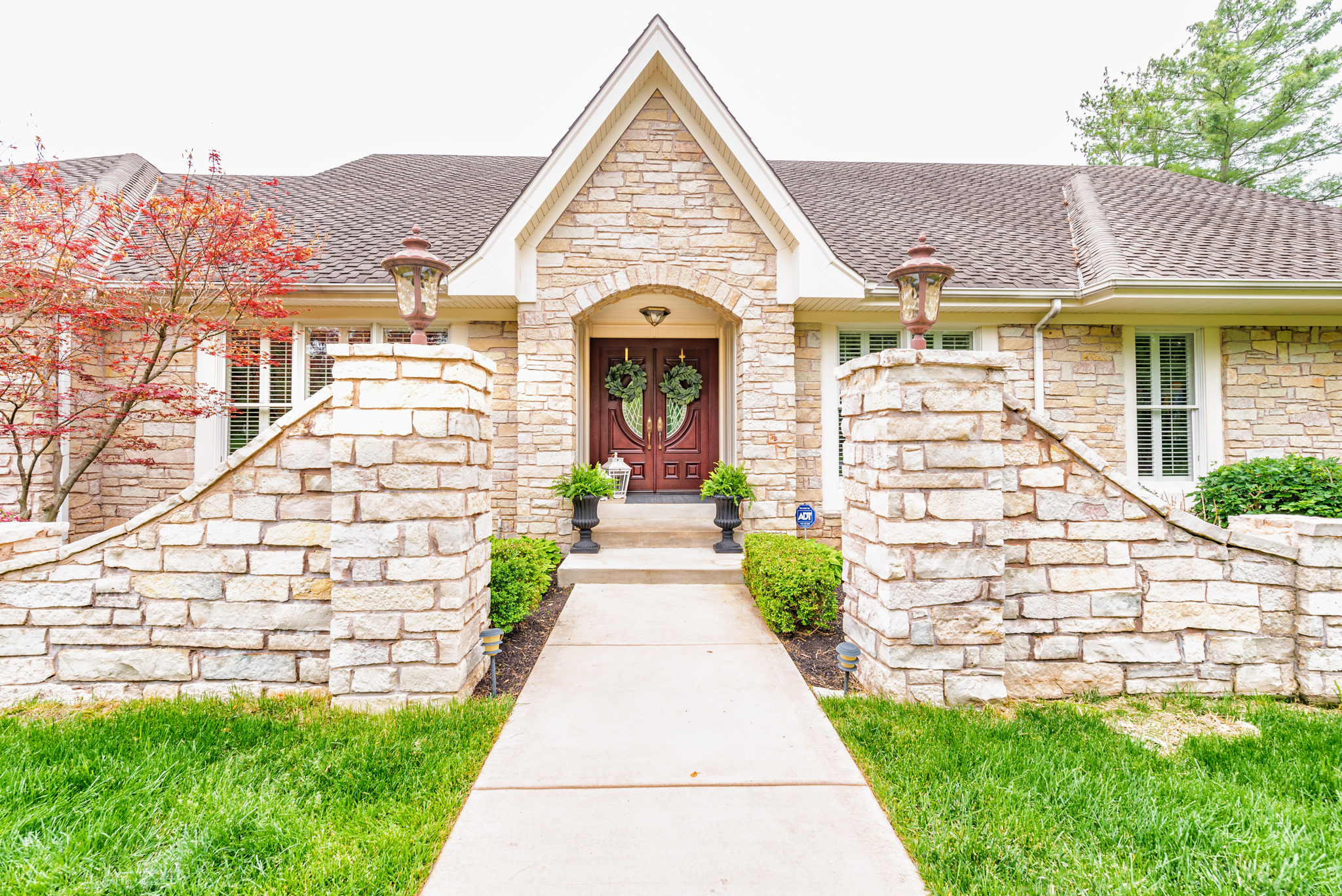 Stone home with an arched entryway and covered porch